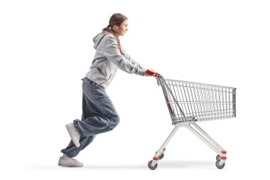 Beyaz arka planda izole edilmiş alışveriş arabasıyla koşan genç kız.