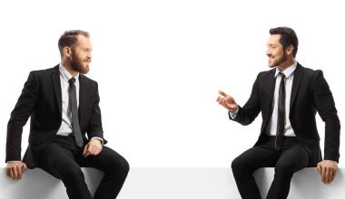 İş adamları panelde oturup beyaz arka planda izole bir şekilde sohbet ediyorlar.
