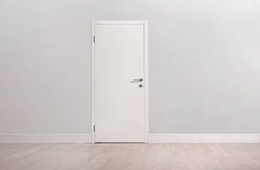 Gri duvardaki beyaz iç kapı.