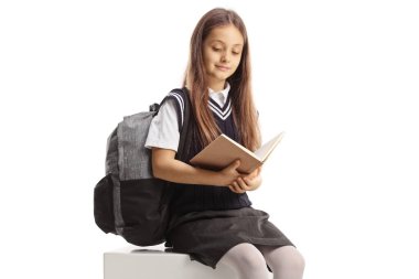 Öğrenci beyaz arka planda izole edilmiş bir kitap okuyor.