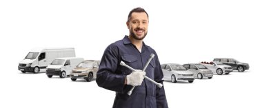 Otopark ve oto tamircisi beyaz arka planda izole edilmiş bir ingiliz anahtarı tutuyor.