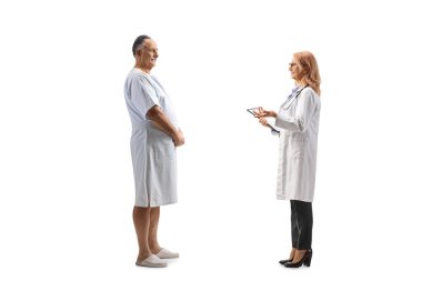 Kadın doktor, beyaz arka planda, hastane önlüğü giymiş bir hastayla konuşuyor.