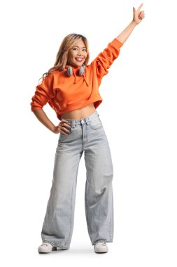 Beyaz arka planda yalnız dans eden kulaklıklı Asyalı genç bir kadın.