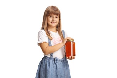 Elinde doğal organik bal dolu bir kavanoz tutan ve beyaz arka planda izole bir şekilde gülümseyen küçük bir kız.
