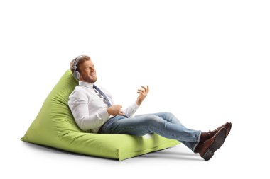 İş adamı koltuğu ve beyaz arka planda izole edilmiş müzik dinlemek
