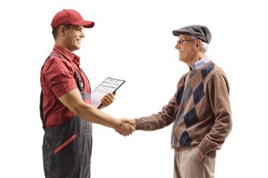 Üniformalı bir işçi beyaz arka planda izole edilmiş yaşlı bir adamla el sıkışıyor.