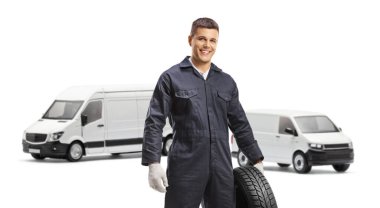 Beyaz arka planda izole edilmiş minibüs lastikleri taşıyan bir otomobil tamircisi.