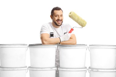 Beyaz arka planda izole edilmiş kameraya gülümseyen boya kovalarının arkasındaki ressam.