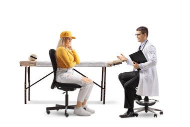 Doktor beyaz arka planda izole edilmiş genç ve düşünceli bir kadın hastayla konuşuyor.