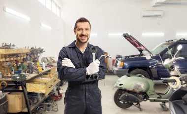 Garaj atölyesinde anahtarı ve anahtarı tutan tamirci.