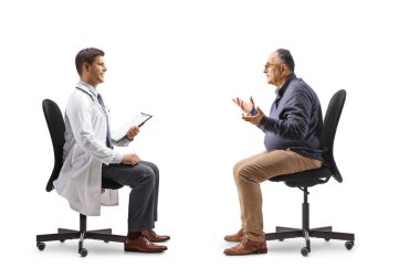 Sandalyeye oturup beyaz arka planda izole edilmiş bir erkek doktorla konuşan olgun bir adam.