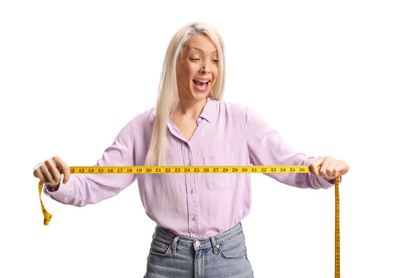 Возбужденная молодая женщина держит изоленту меры на белом фоне