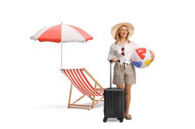 Elinde bavul ve güverte sandalyesinin önündeki plaj topuyla beyaz arka planda izole edilmiş bir kadın.