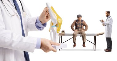 Kayropraktik merkezinde yaşlı bir adam beyaz arka planda izole edilmiş bir doktorla konuşuyor.
