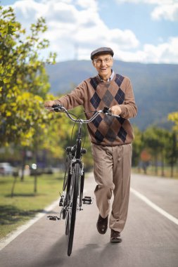 Parkta bisiklet süren yaşlı bir adam