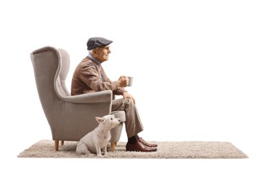 Koltukta oturan ve elinde beyaz arka planda izole edilmiş bir bardak tutan yaşlı bir adam.