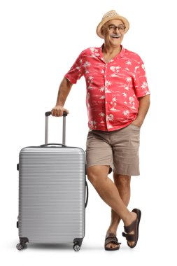 Beyaz arka planda kameraya gülümseyen bavullu bir erkek turist.