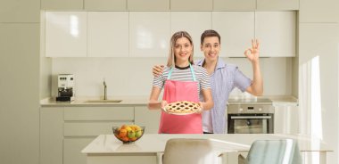 Mutfakta turtası olan mutlu genç bir çift.