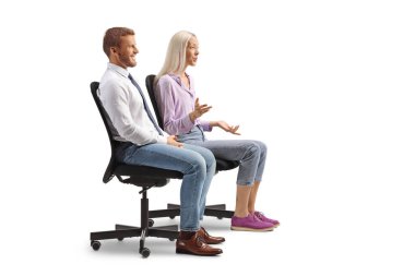 Kadın ve erkek ofis sandalyelerinde oturuyor ve beyaz arka planda yalnız konuşuyorlar.