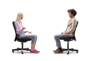 Kadın bir ofis sandalyesinde oturuyor ve beyaz arka planda izole edilmiş bir adamla konuşuyor.