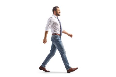 Gömlekli ve kot pantolonlu bir adamın beyaz arka planda tek başına yürürken tam boy profil fotoğrafı.