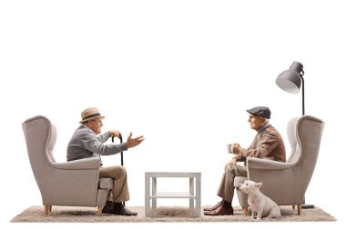 İki kıdemli adam beyaz arka planda izole bir şekilde oturuyor ve konuşuyorlar. 