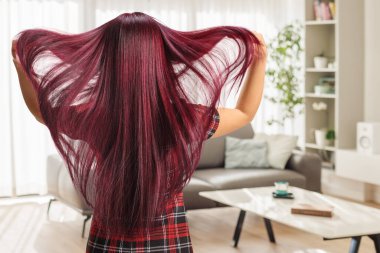 Uzun saçlı bir kadının oturma odasında dikiz görüntüsü.