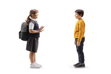 Okul üniformalı bir kız sırt çantası taşıyor ve beyaz arka planda izole edilmiş bir çocukla konuşuyor.