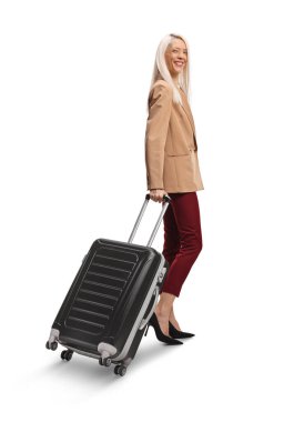 Beyaz arka planda, bavulu çeken ve gülümseyen bir kadın.