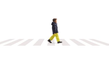 Beyaz arka planda, zebra geçidinde yürüyen, kışlık elbiseli bir çocuğun tam boy profil fotoğrafı.