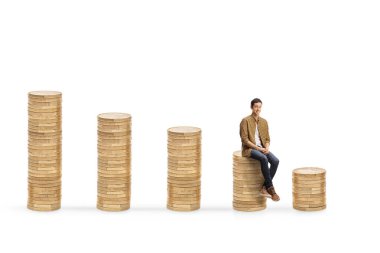 Beyaz arka planda izole edilmiş madeni paraların üzerinde oturan sıradan bir genç.