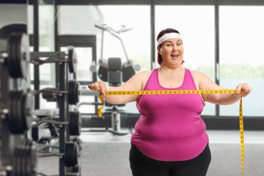 Ayrıca spor salonunda elinde mezura tutan etkin bir kadın.