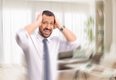 Aklını kaybetmiş bir adam başını tutuyor ve başı dönüyor. 