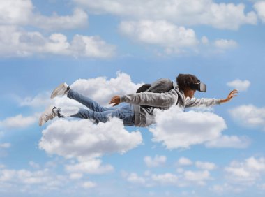 Gökyüzünde vr kulaklıkla uçan Afrikalı Amerikalı erkek öğrenci