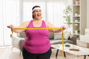 Artı evde elinde mezura tutan etkin bir kadın.