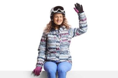 Ceketli ve kayak gözlüklü genç bir kadın beyaz arka planda izole edilmiş.