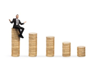 Zengin işadamı, beyaz arka planda izole edilmiş bozuk paraların üzerinde oturuyor.