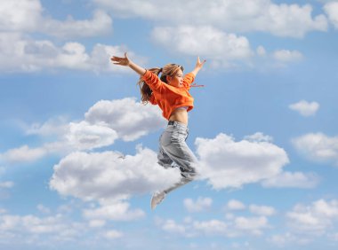 Genç Asyalı kadın dansçı gökyüzüne atlıyor.