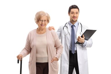 Doktor ve bastonlu yaşlı bir kadın hasta beyaz arka planda yalnız poz veriyorlar.