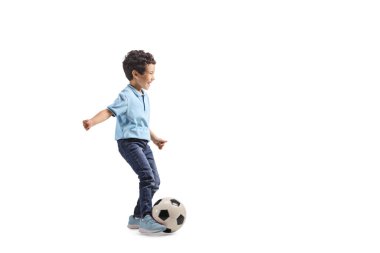Asyalı bir çocuğun beyaz arka planda izole edilmiş bir futbol topuyla koşarken tam boy profil fotoğrafı.