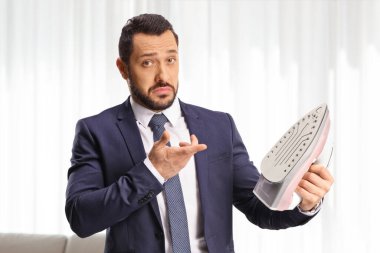 Elinde ütü tutan sinirli bir adam.