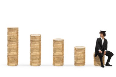 Erkek Afrikalı Amerikalı mezun öğrenci bir yığın madeni paranın üzerinde oturuyor ve beyaz arka planda izole bir şekilde geriye bakıyor.