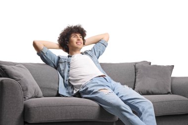 Mutlu genç adam beyaz arka planda izole bir kanepede dinleniyor.