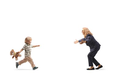 Beyaz arka planda izole edilmiş bir kadına sarılmak için koşan oyuncak ayılı bir çocuk.