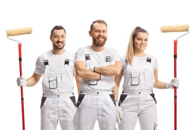 Beyaz pantolonlu ev ressamları beyaz arka planda izole edilmiş kameraya gülümsüyor.