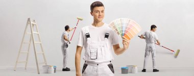 Bir renk paleti tutan genç bir postacı ve duvar boyayan diğer ressamlar.