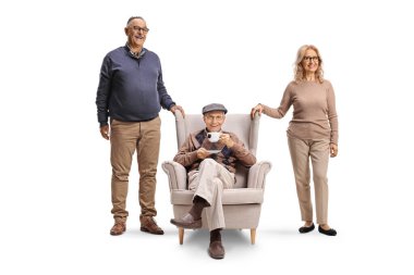 Beyaz arka planda izole edilmiş bir koltukta yaşlı bir babanın yanında duran kadın ve erkek.