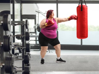 Spor salonunda kum torbasıyla kadın eğitim kutusu, kilo verme konsepti.