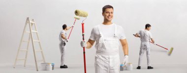 Team of house painters working and painting a wall