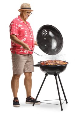 Beyaz arkaplanda ayrıştırılmış çatalla bir bbq açıp eti kontrol eden adam